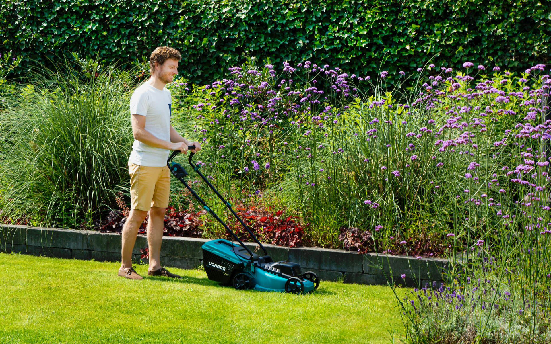 Mann mäht seinen Rasen mit seinem VONROC-Akku-Rasenmäher