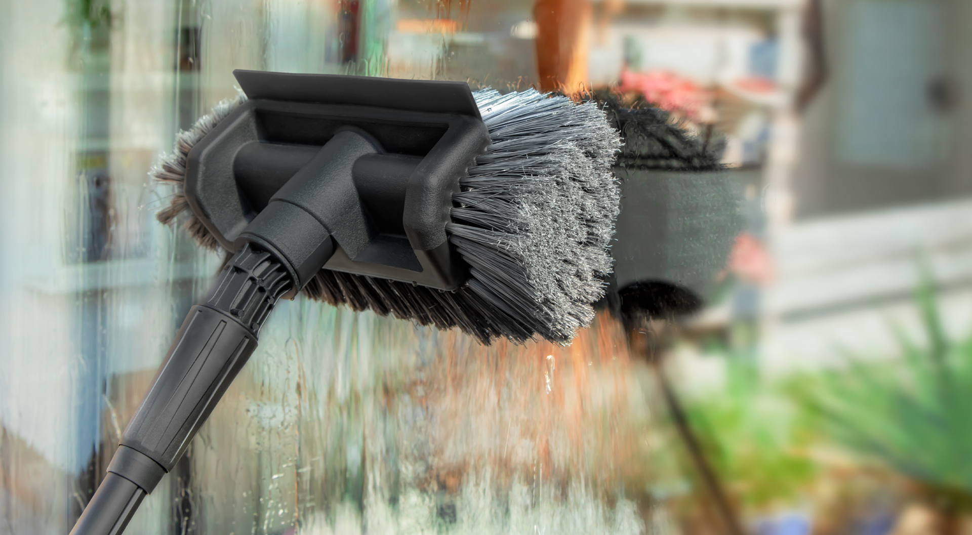 Fensterreinigung mit einer VONROC-Waschbürste.